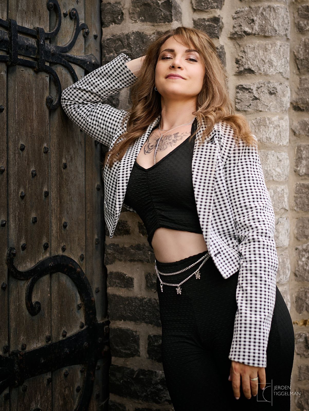 Portrait debout devant une porte ancienne